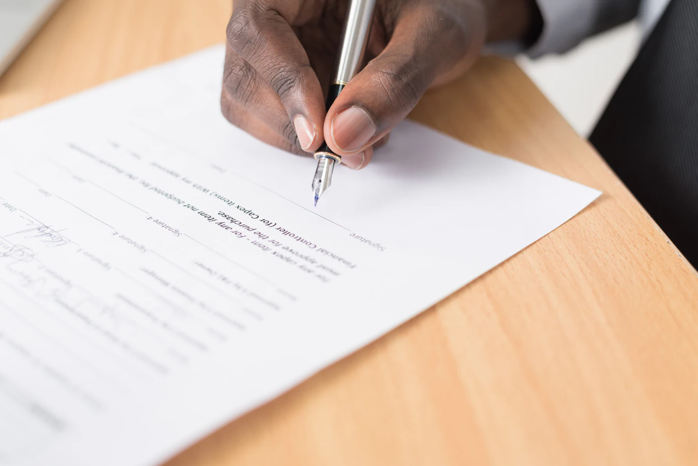 A person writing on a printed document with a pen