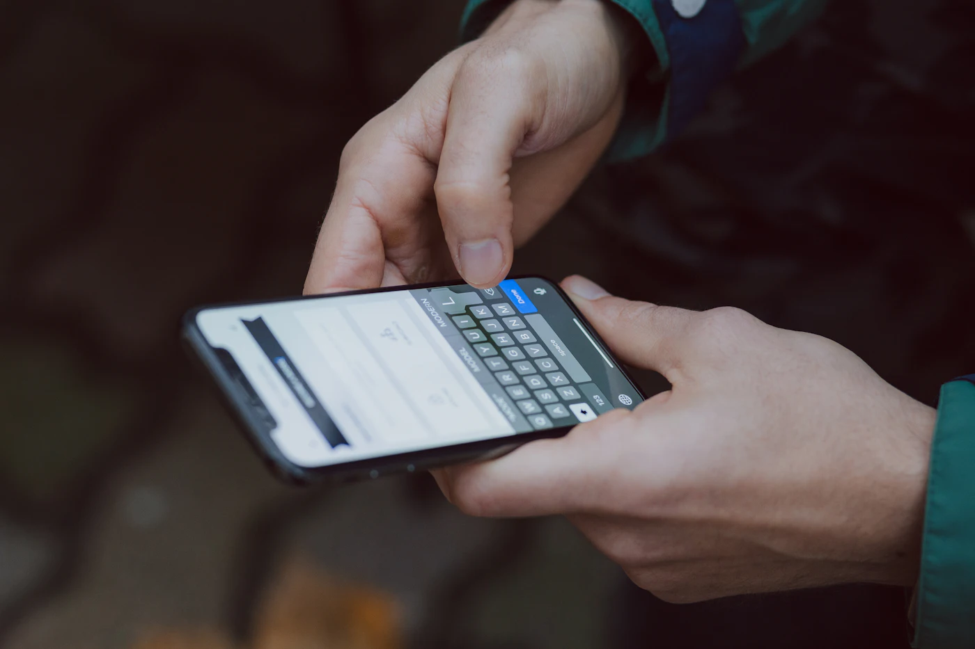 A hand holding a smartphone with a messaging app open
