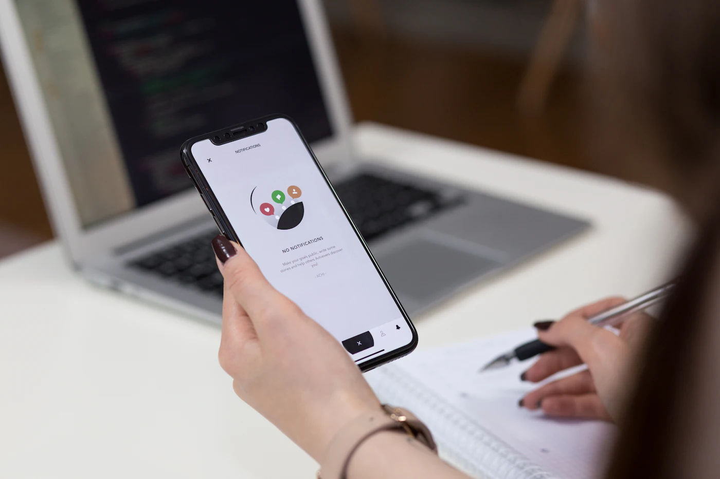 A person holding a smartphone with the screen switched on
